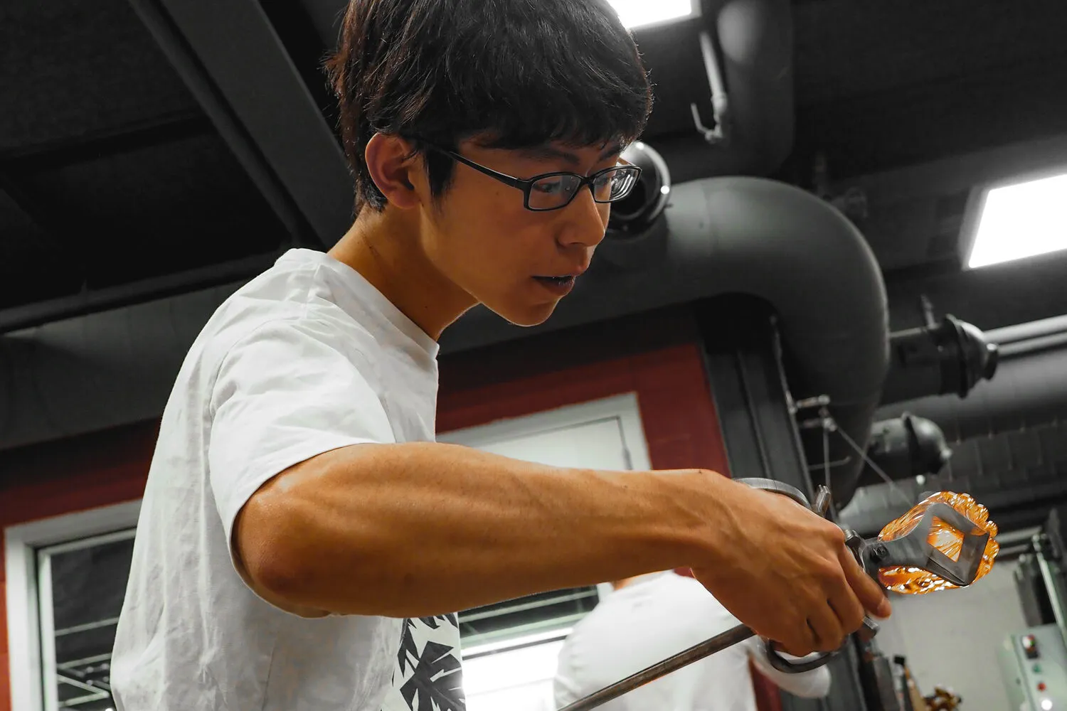 Akito Yamauchi shaping hot glass at the bench