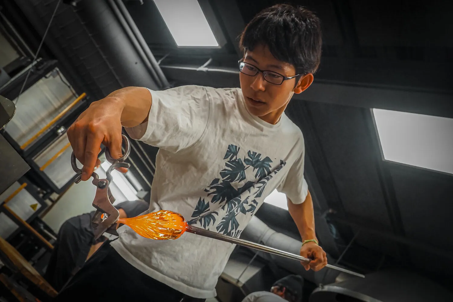 Akito Yamauchi shaping hot glass at the bench