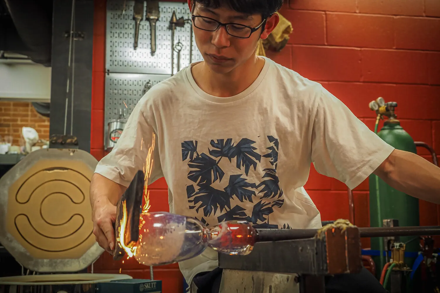 Akito Yamauchi shaping hot glass at the bench