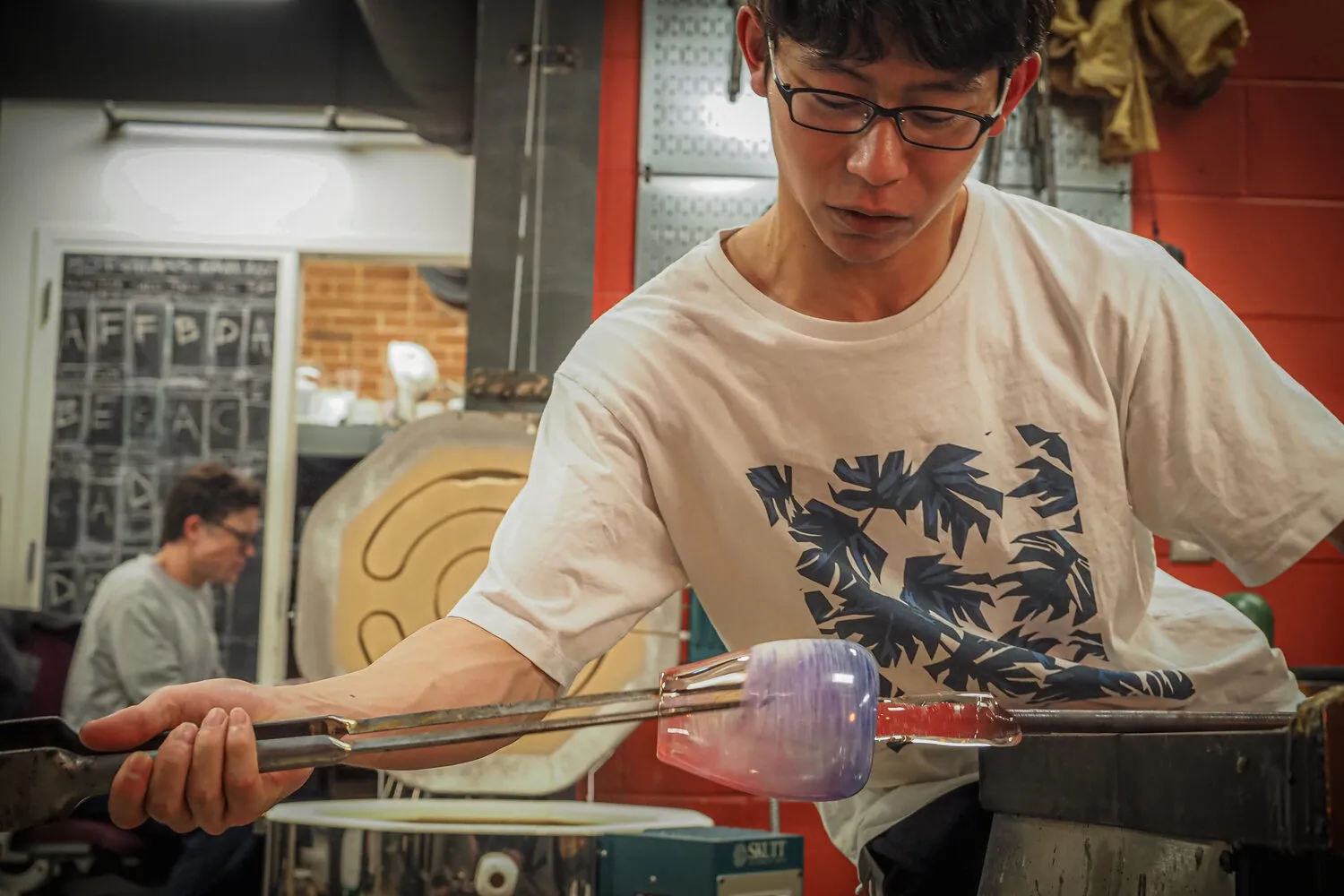 Akito Yamauchi shaping hot glass at the bench