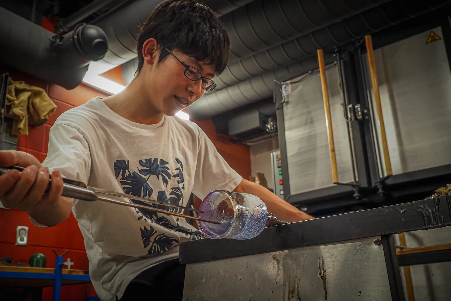 Akito Yamauchi shaping hot glass at the bench